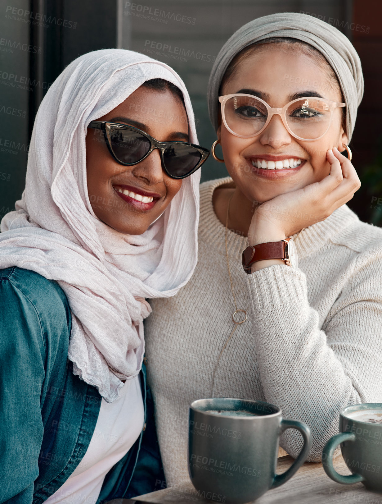 Buy stock photo Friends, muslim and women with coffee at cafe in hijab of conversation, drink and bonding on lunch date. Portrait, people and islam culture or designer glasses, discussion and social restaurant