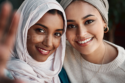 Buy stock photo Cropped portrait of two affectionate young girlfriends taking a selfie together at a cafe while dressed in hijab