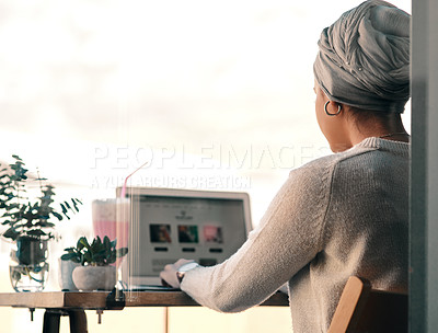 Buy stock photo Rearview shot of an unrecognizable woman using a laptop at a milkshake cafe while wearing a headscarf