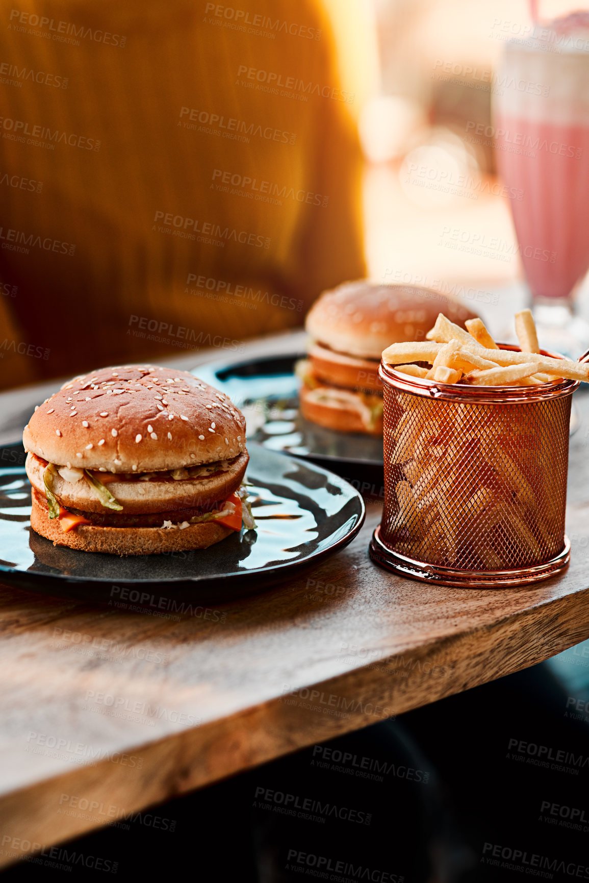 Buy stock photo Fries, burger and person at outdoor restaurant for nutrition with brunch, milkshake and hungry for meal. Woman, cafeteria and fast food sandwich with chips for lunch craving, dessert drink and eating