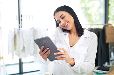 Buy stock photo Shot of a young business owner talking on her cellphone while using a digital tablet in her store