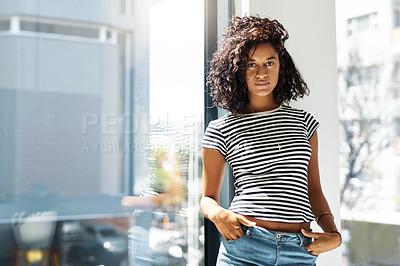 Buy stock photo Cropped portrait of an attractive young woman standing alone and posing against the window in her home