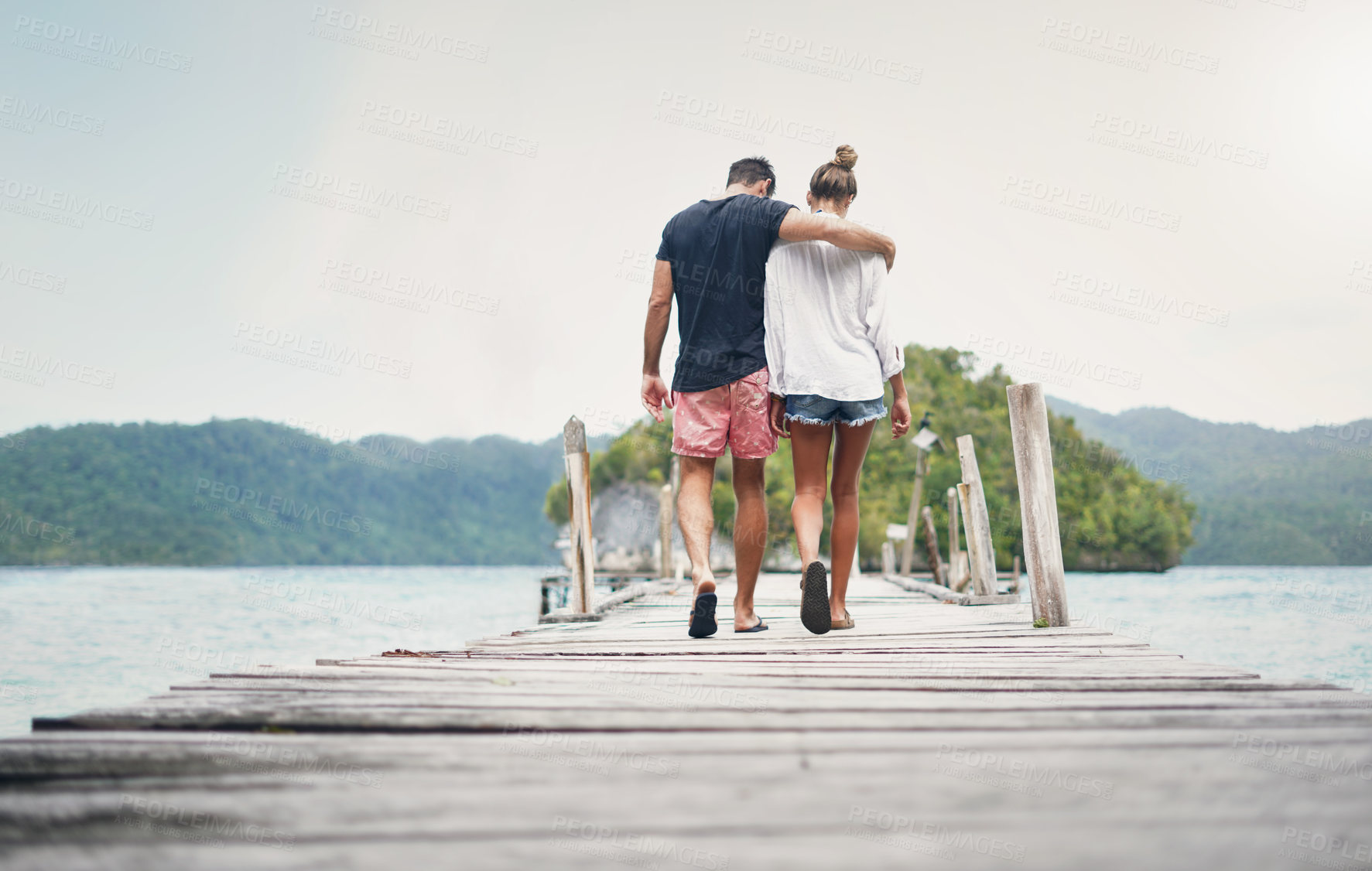 Buy stock photo Couple, vacation and walking on ocean boardwalk for travel, freedom and peace. Back of a man and woman hug and walk to relax on Indonesia holiday, tropical adventure or nature date at sea on a deck
