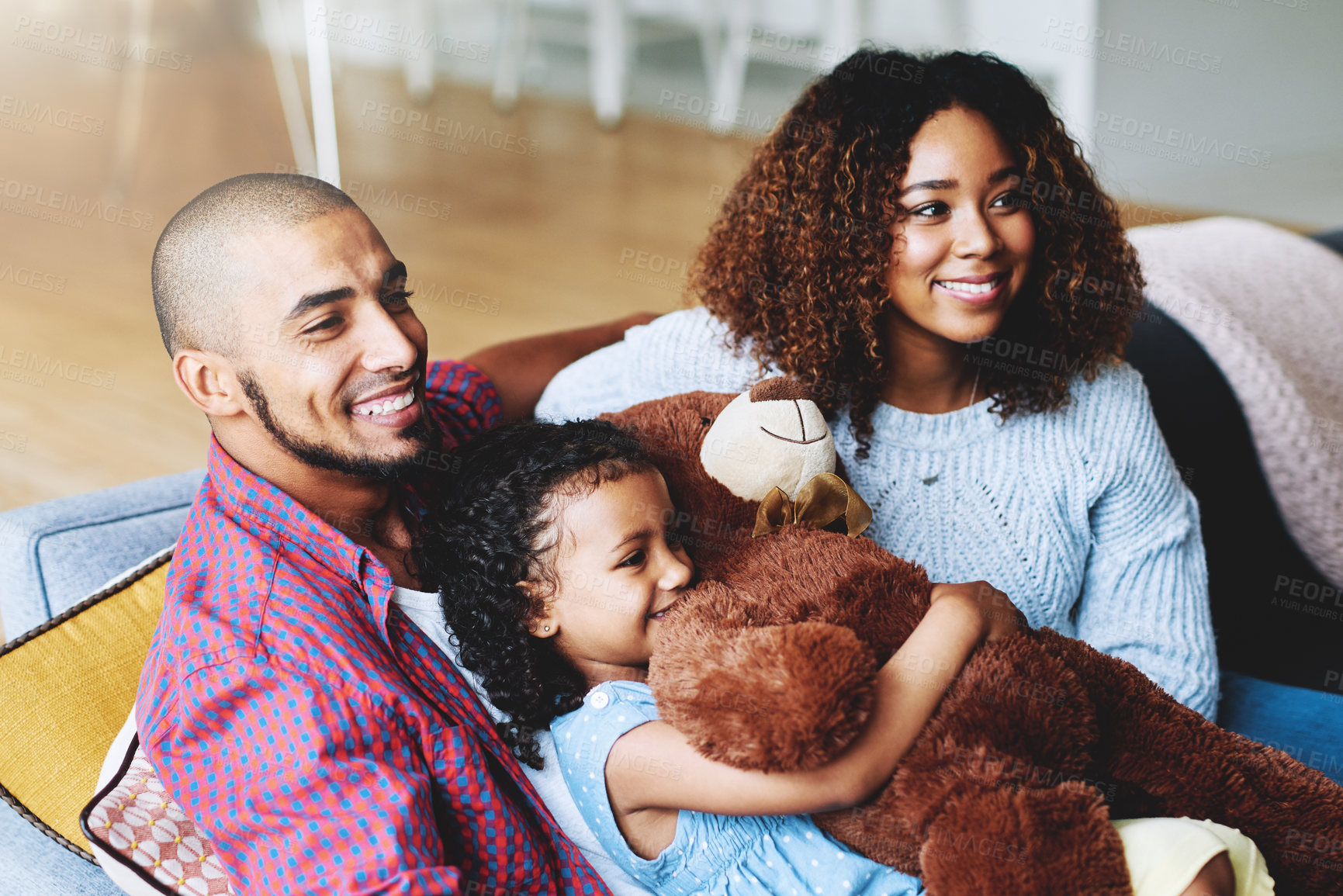 Buy stock photo Cropped shot of a happy young family of three relaxing together in their living room at home