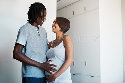 Buy stock photo Shot of happy young man posing with his pregnant wife at home