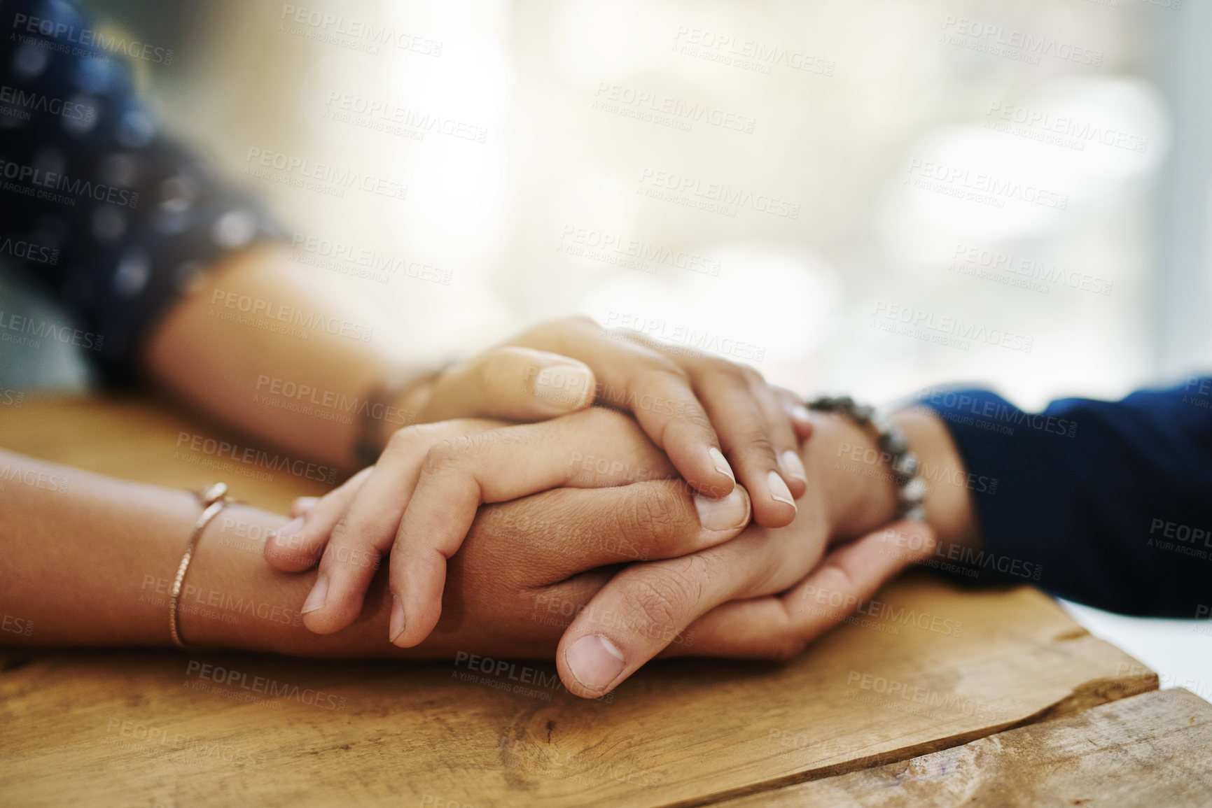 Buy stock photo Holding hands, support and closeup with trust, solidarity and community on a home table. Therapy, diversity and gratitude of friends together with hope, respect and love for grief empathy and forgive