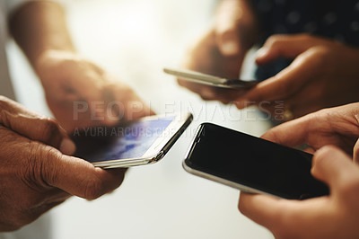 Buy stock photo Closeup shot of a group of unrecognizable businesspeople using their cellphones in synchronicity