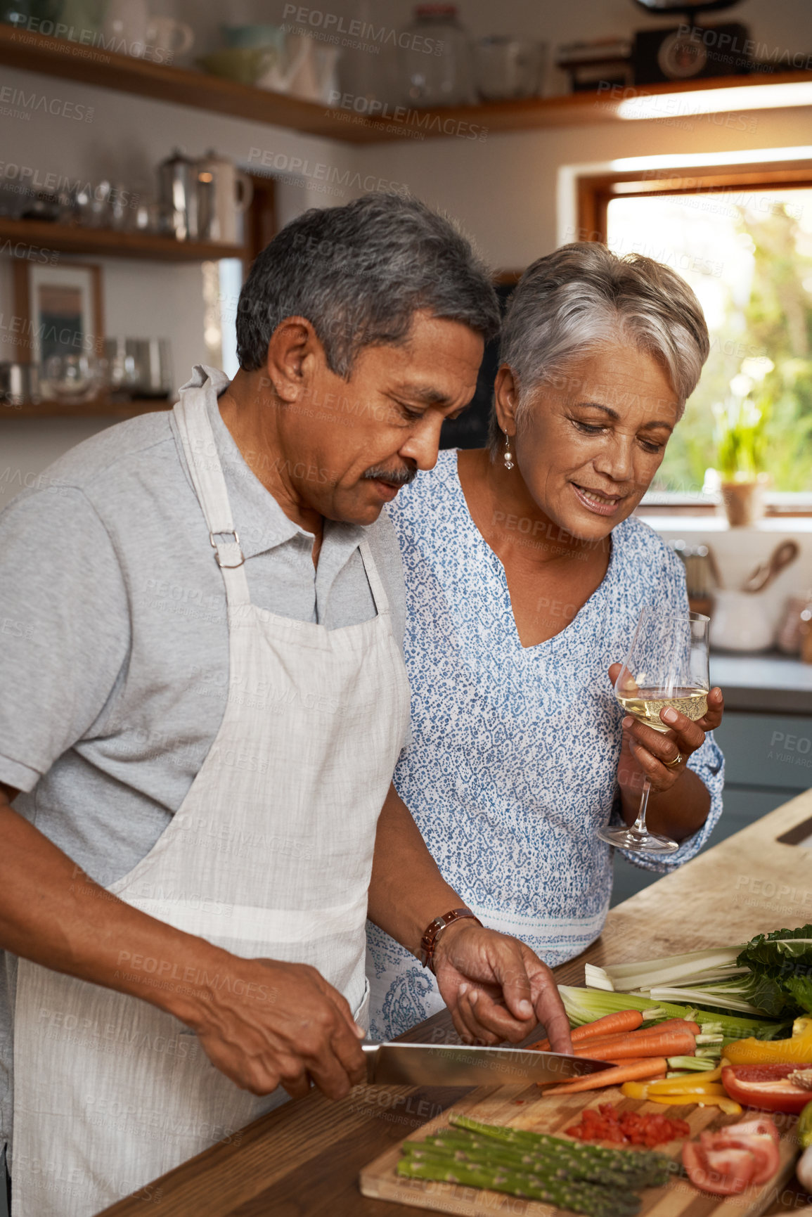 Buy stock photo Vegetables, cooking and old couple with wine in kitchen, healthy food and marriage time together in home for dinner. Drink, glass and senior woman with man, meal prep and wellness diet in retirement.