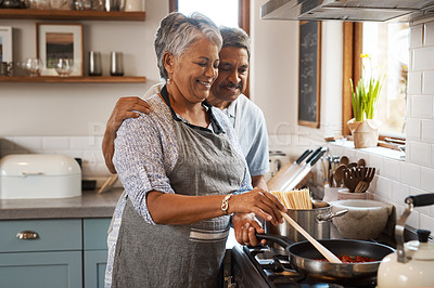 Buy stock photo Love, cooking and old man with happy woman at stove in kitchen, embrace and healthy marriage bonding in home. Happiness, help and food in pan, senior couple with smile, hug and dinner in retirement.