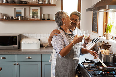 Buy stock photo Cheers, wine and senior couple in kitchen cooking healthy food together on stove with smile, health and romance. Toast, drinks and old woman with man, glass and happiness, meal in pan and retirement.