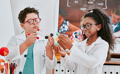 Buy stock photo Shot of two adorable young school children learning about molecules in science class at school