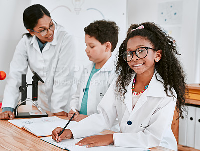 Buy stock photo Portrait of an adorable young school girl writing notes in science class with her teacher and classmate in the background