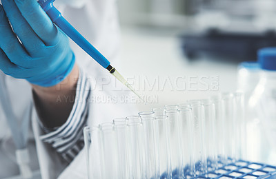 Buy stock photo Cropped shot of an unrecognizable female scientist transferring a liquid sample from a dropper into test tubes while working in a laboratory