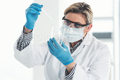 Buy stock photo Cropped shot of an attractive young female scientist dropping a liquid sample into a beaker while working in a laboratory