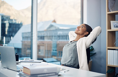 Buy stock photo Shot of a young businesswoman relaxing at her desk in a modern office