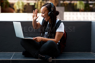 Buy stock photo Shot of an attractive young woman using her laptop to make a video call outdoors