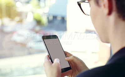 Buy stock photo Cropped shot of an unrecognizable young businesswoman using a mobile phone while standing on her office balcony