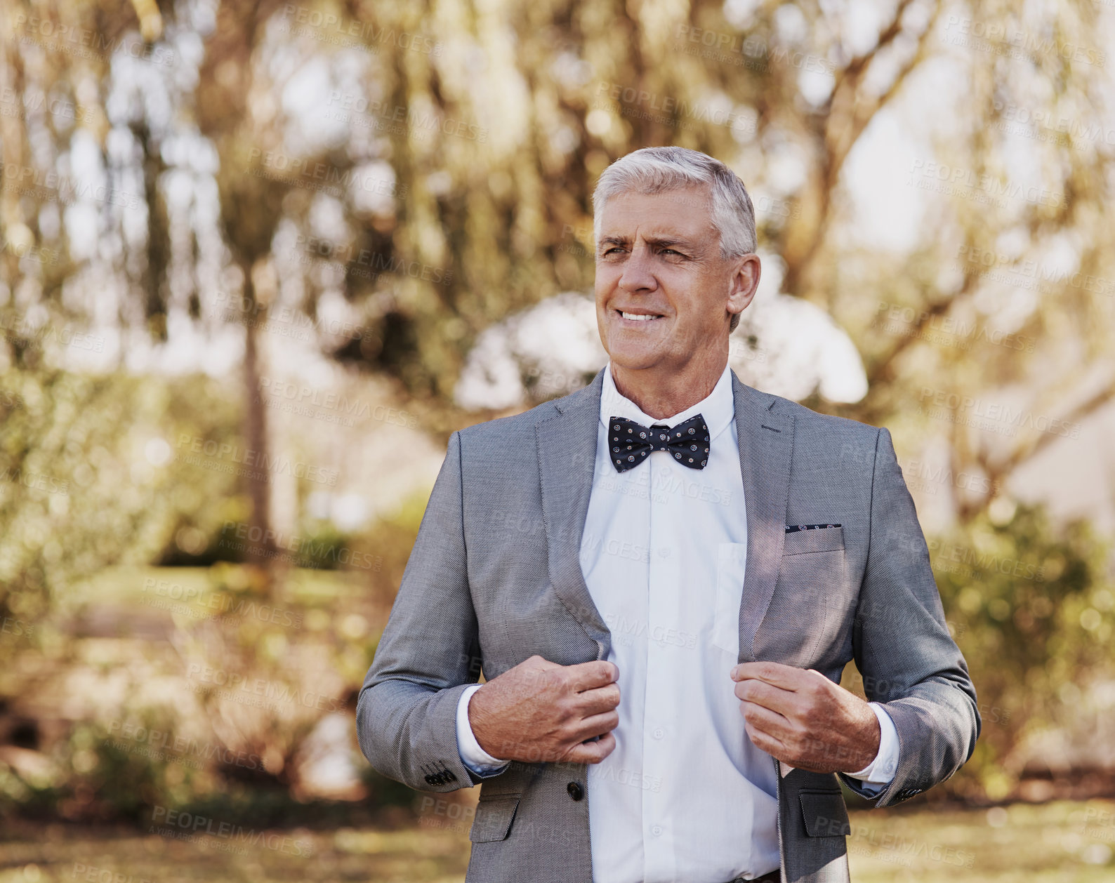 Buy stock photo Cropped shot of a handsome mature bridegroom looking thoughtful while adjusting his suit on his wedding day