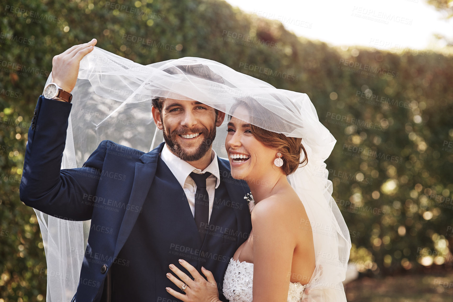 Buy stock photo Wedding, veil and couple with love, marriage and celebration for relationship, loyalty and commitment. Portrait, bride or groom with a smile, married or cover with dress with happiness in a garden