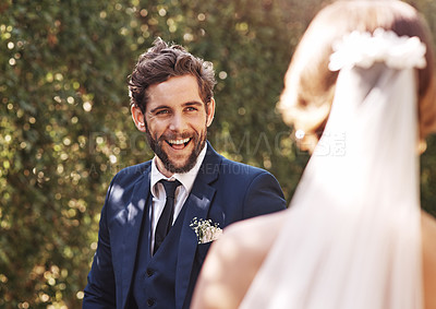 Buy stock photo Cropped shot of an affectionate young bridegroom smiling at his bride while standing outdoors on their wedding day