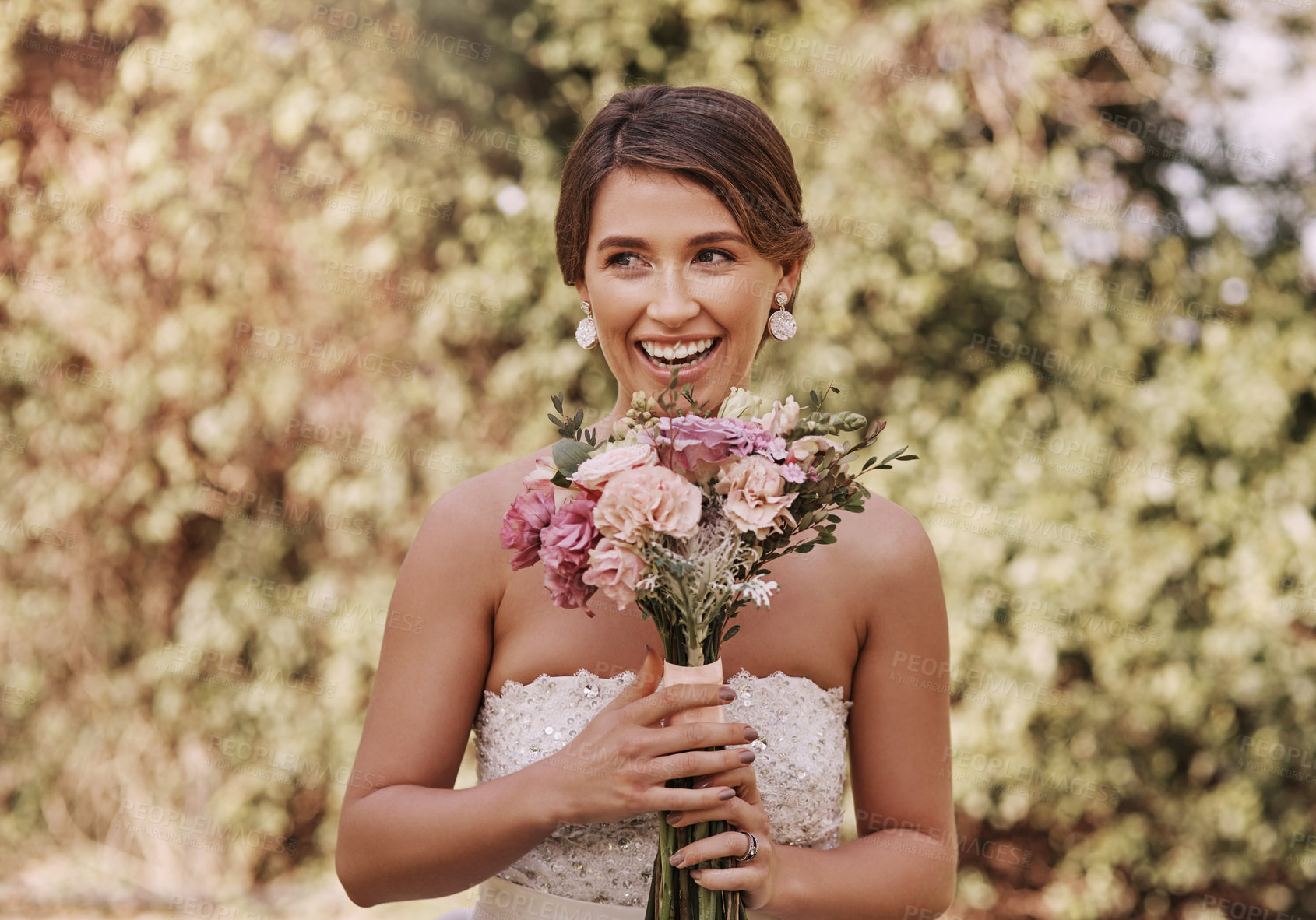 Buy stock photo Cropped shot of a beautiful young bride smiling while standing with a bouquet in her hands on her wedding day