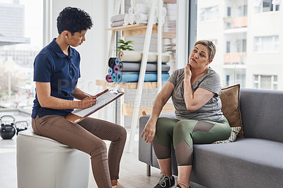 Buy stock photo Shot of a young physiotherapist consulting with a mature woman inside her office at a clinic