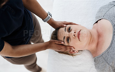 Buy stock photo Shot of a mature woman getting her head and neck treated by a physiotherapist at a clinic