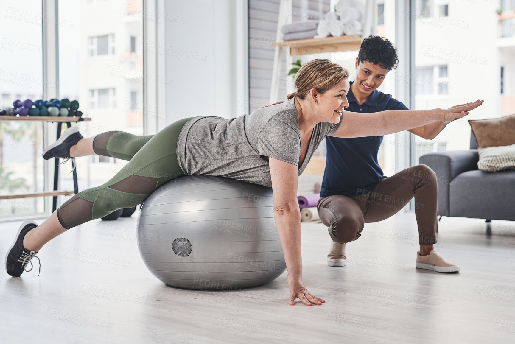 Buy stock photo Physiotherapy, women and gym ball for exercise, wellness and help in health, clinic or session. Female people, trainer and patient with physiotherapist, fitness or stretching in rehabilitation center