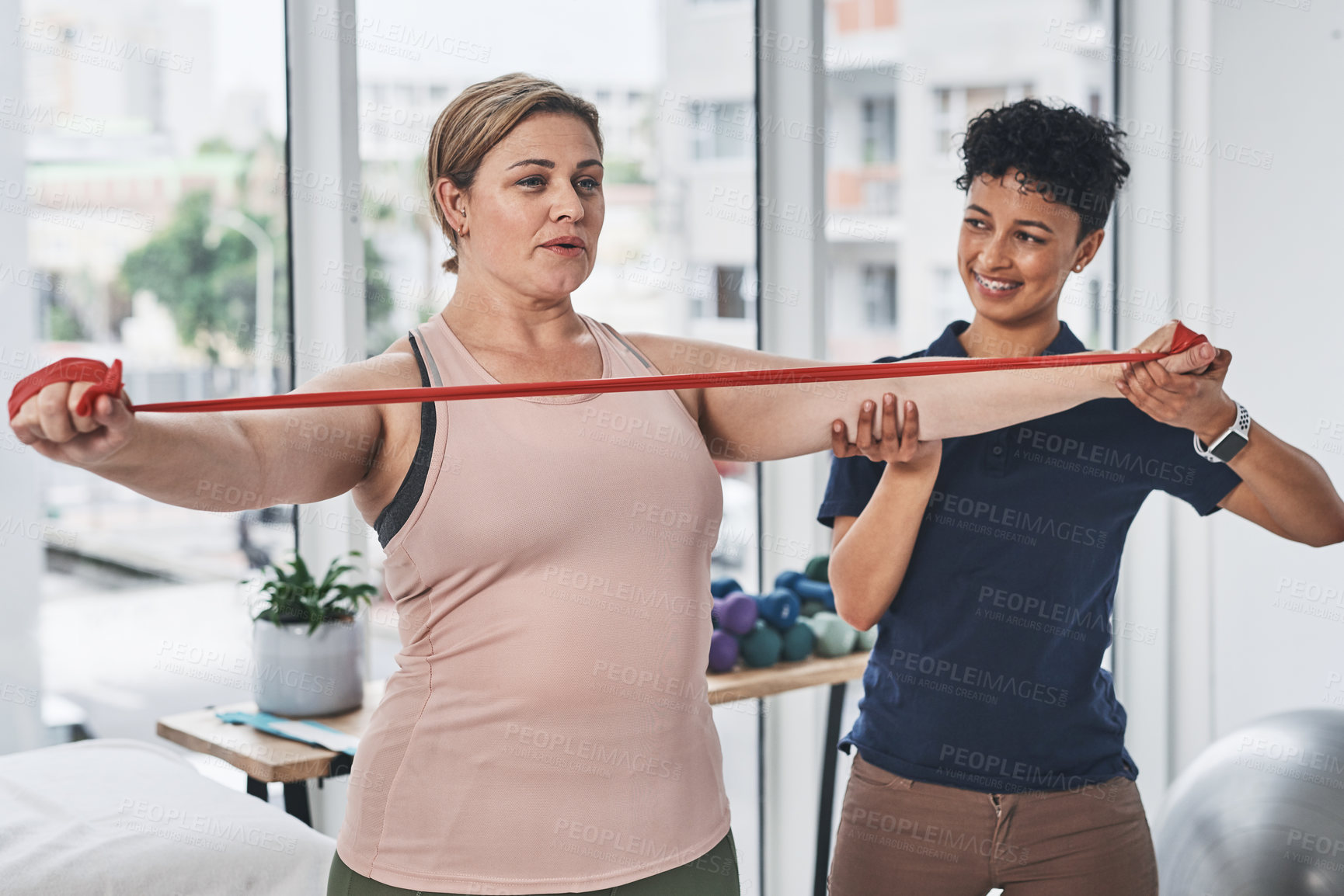 Buy stock photo Physiotherapist, woman and resistance band for exercise, wellness in gym, clinic or session. Female people, trainer and patient with physiotherapy, fitness and strong muscle in rehabilitation center
