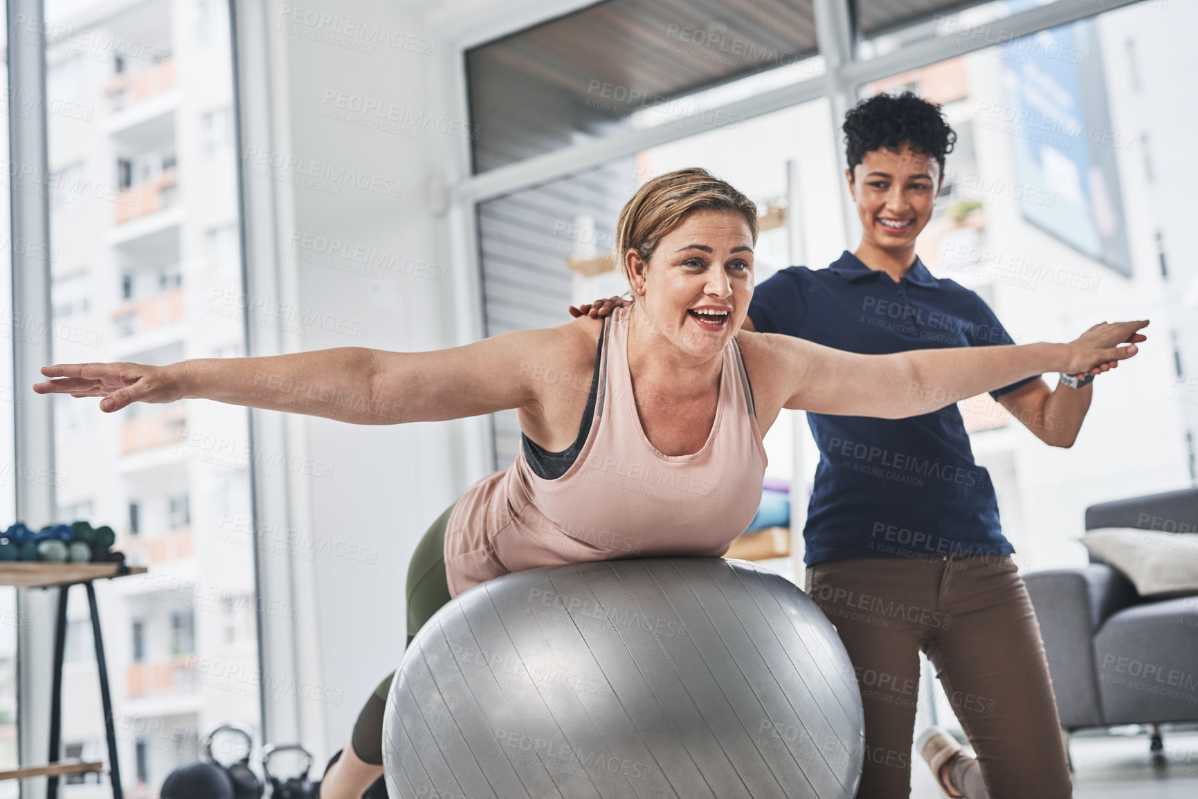 Buy stock photo Shot of a mature woman doing rehabilitation and movement exercises with her physiotherapist at a clinic