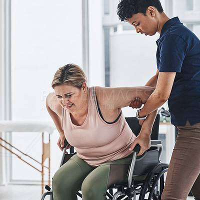 Buy stock photo Cropped shot of a young physiotherapist doing exercises with her wheelchair bound patient inside her office at a clinic