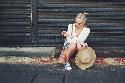 Buy stock photo Full length shot of an upset young woman checking the time on her wristwatch while sitting outdoors