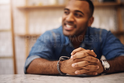 Buy stock photo Cropped shot of a handsome young businessman leaning on the counter in his cafe with his hands clasped