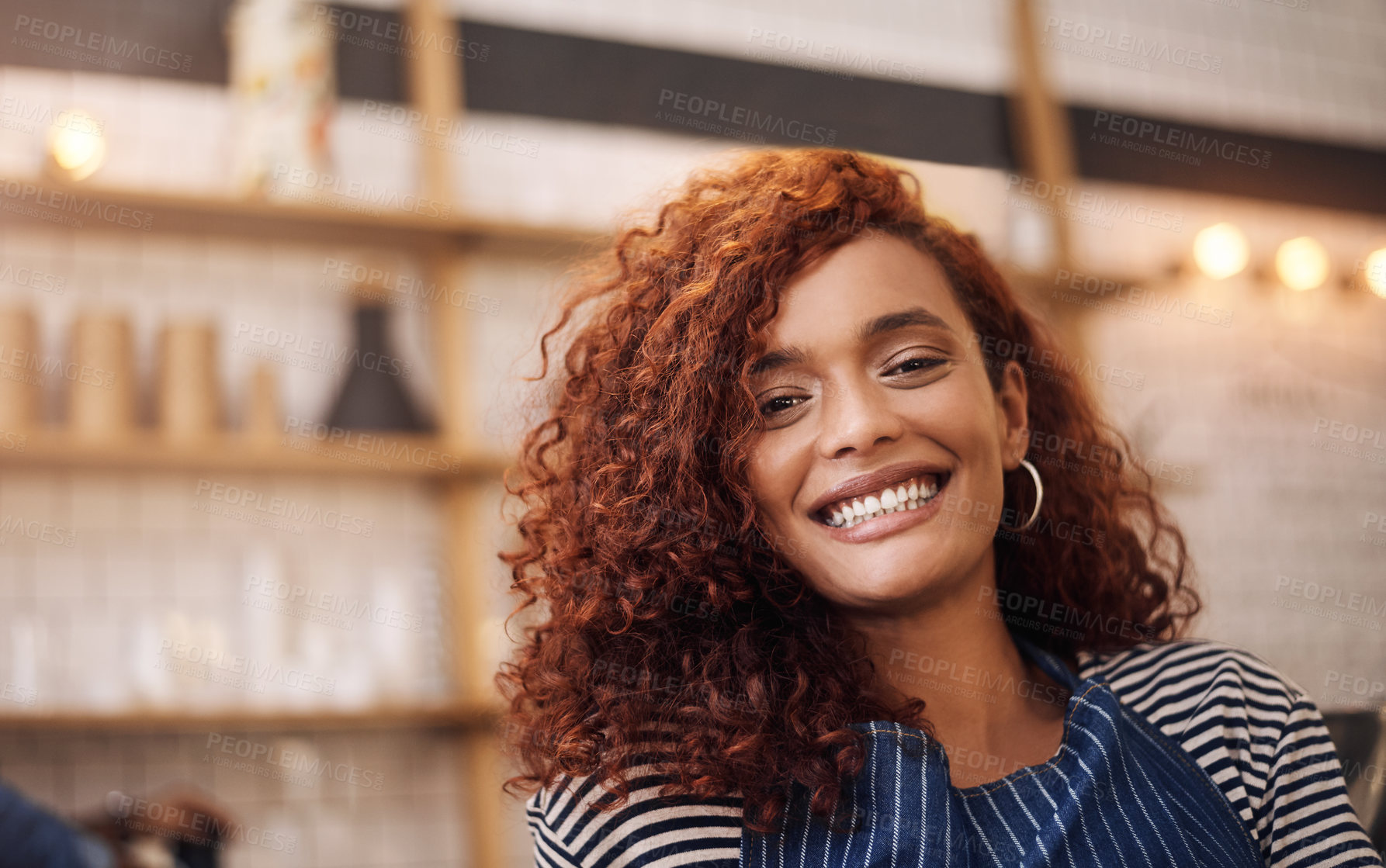 Buy stock photo Cropped shot an attractive young businesswoman standing alone in her cafe and smiling during the day