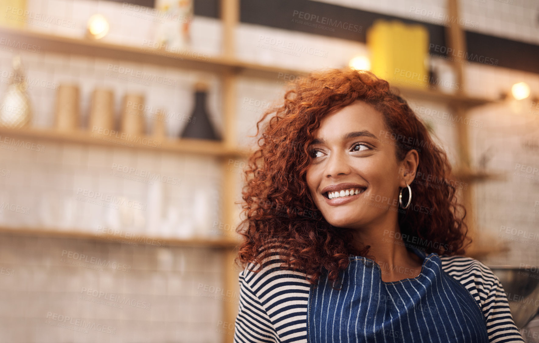 Buy stock photo Cropped shot an attractive young businesswoman standing alone in her cafe and smiling during the day