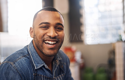 Buy stock photo Cropped shot a handsome young businessman standing alone in his cafe and smiling during the day