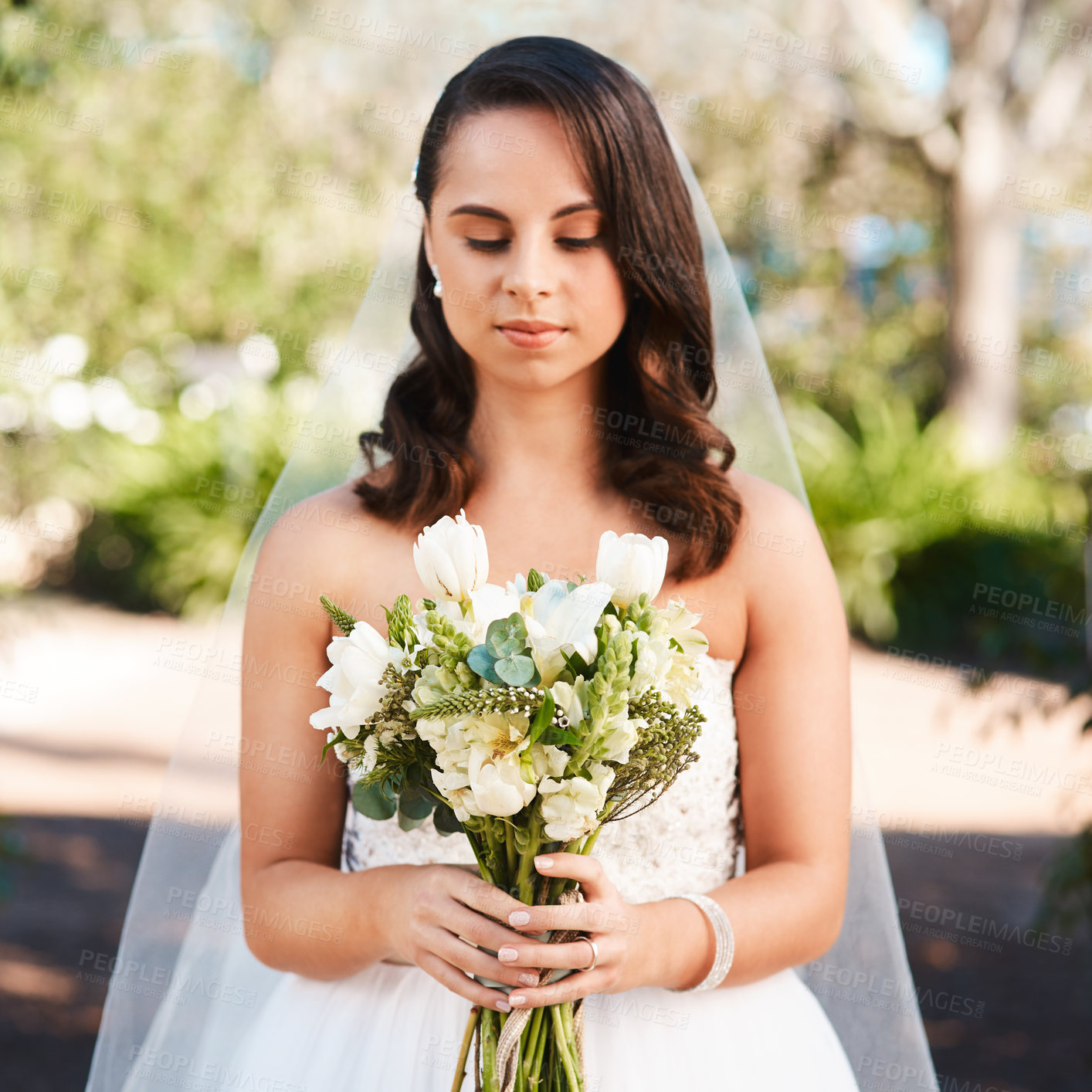 Buy stock photo Cropped shot of a beautiful young bride holding a bouquet of flowers while standing outdoors on her wedding day