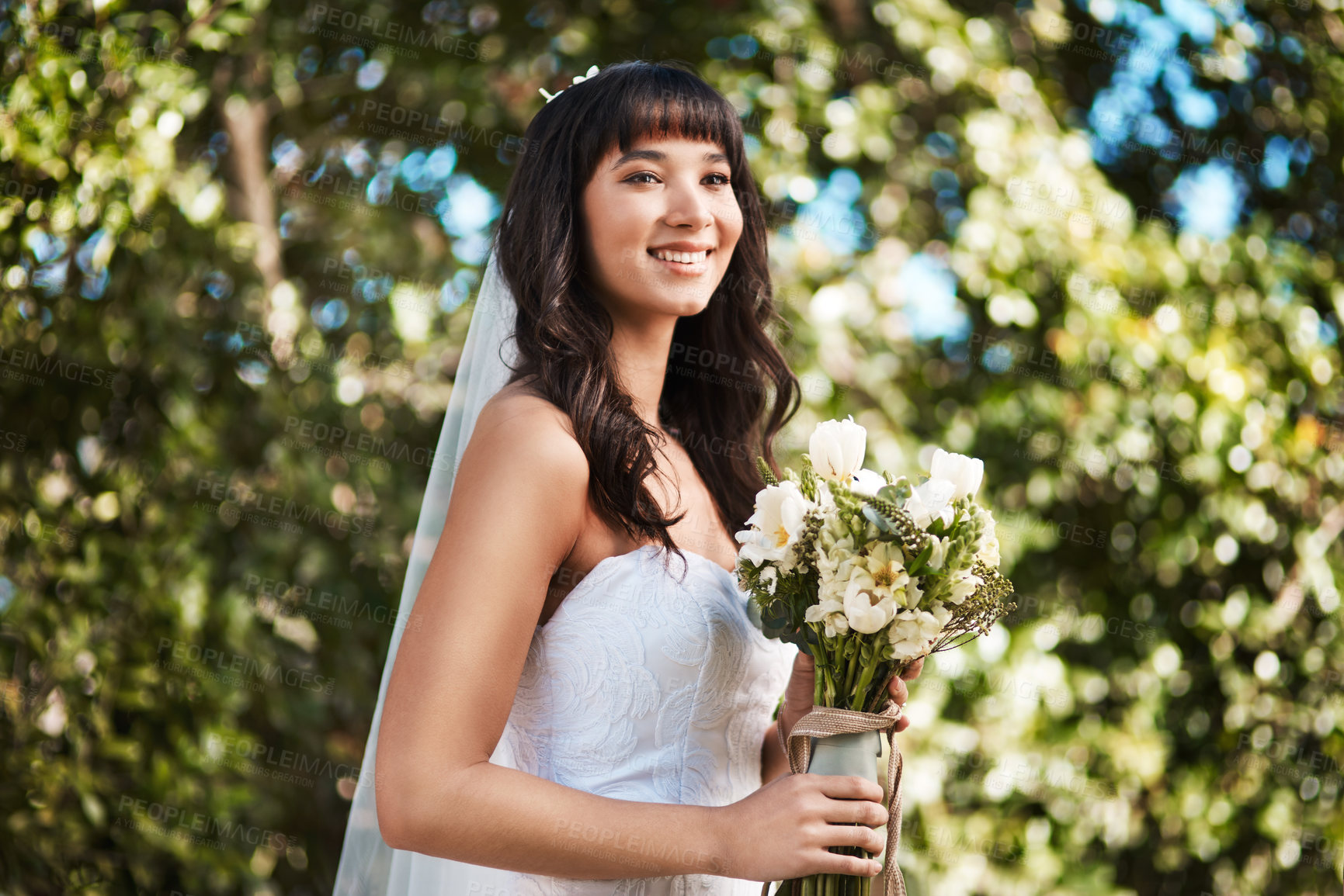 Buy stock photo Cropped shot of a beautiful young bride smiling while holding a bouquet of flowers on her wedding day