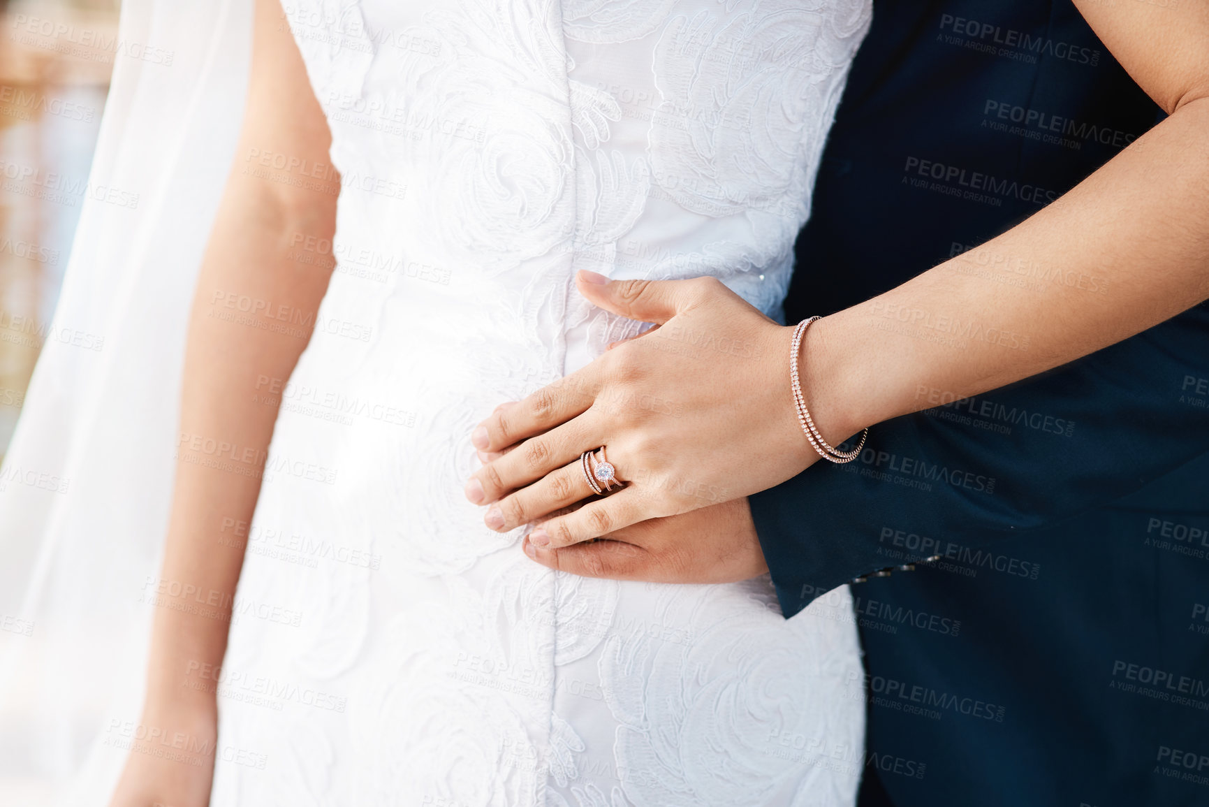 Buy stock photo Cropped shot of an unrecognizable bride showing off her wedding ring while standing with her groom on their wedding day