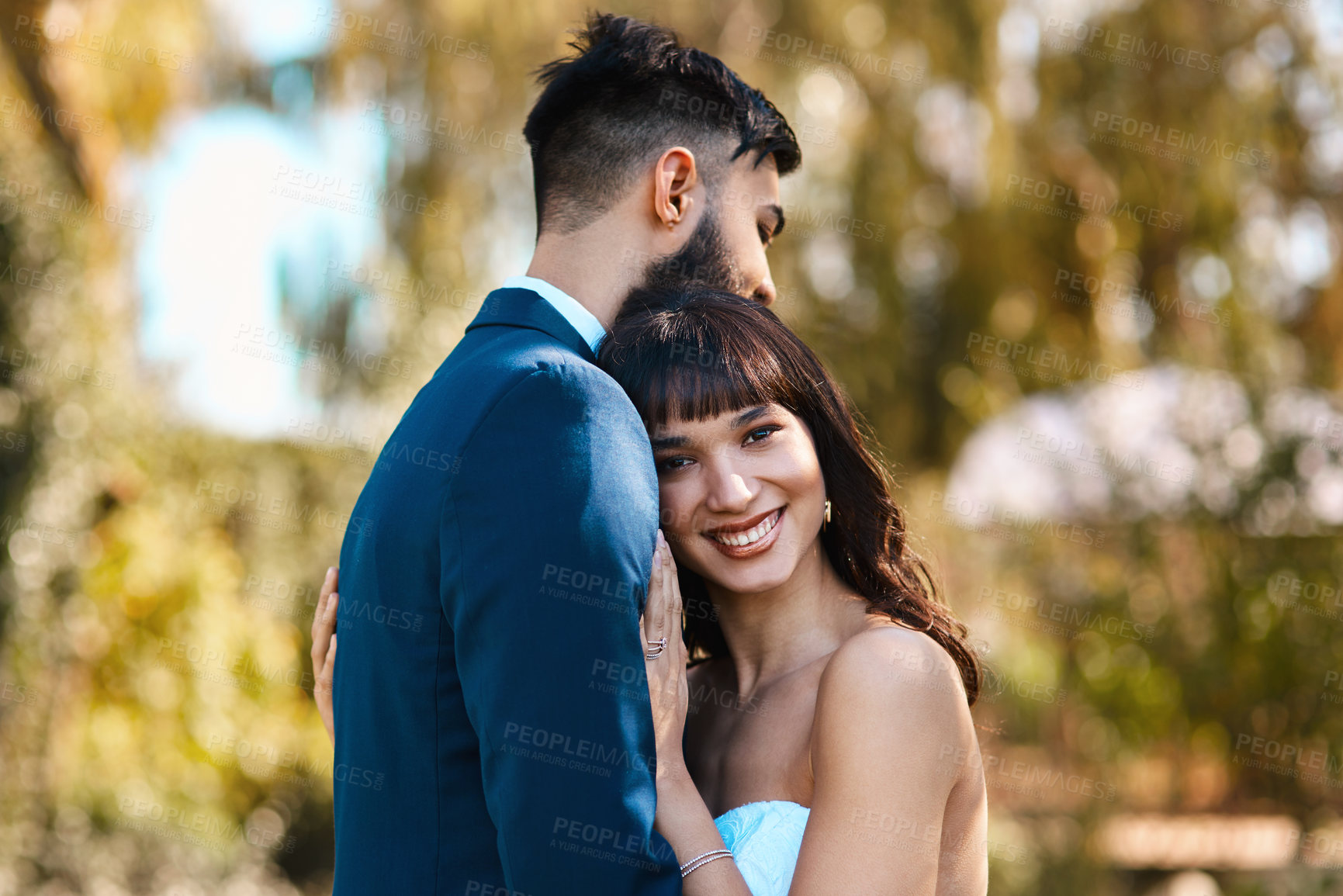 Buy stock photo Cropped shot of an affectionate young bride smiling while leaning on her groom's chest on their wedding day