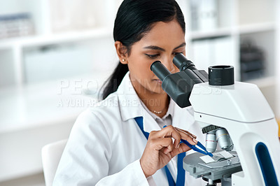 Buy stock photo Cropped shot of an attractive young female scientist placing a microscopic slide under the microscope while working in a laboratory