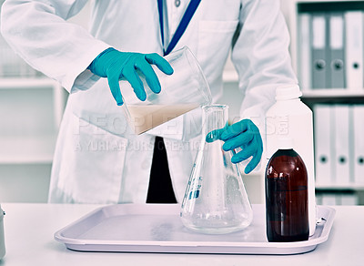 Buy stock photo Cropped shot of an unrecognizable female scientist transferring a liquid from a beaker to a conical flask while working in a laboratory