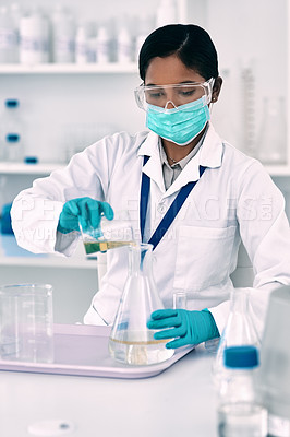 Buy stock photo Cropped shot of an attractive young female scientist transferring a liquid from a beaker to a conical flask while working in a laboratory
