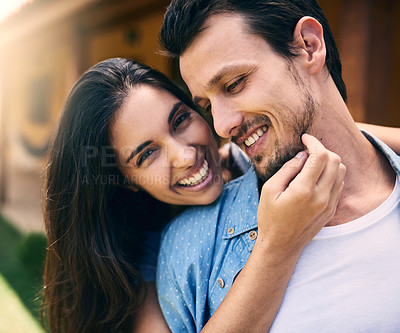 Buy stock photo Cropped shot of an affectionate young woman embracing her husband while standing in their backyard at home