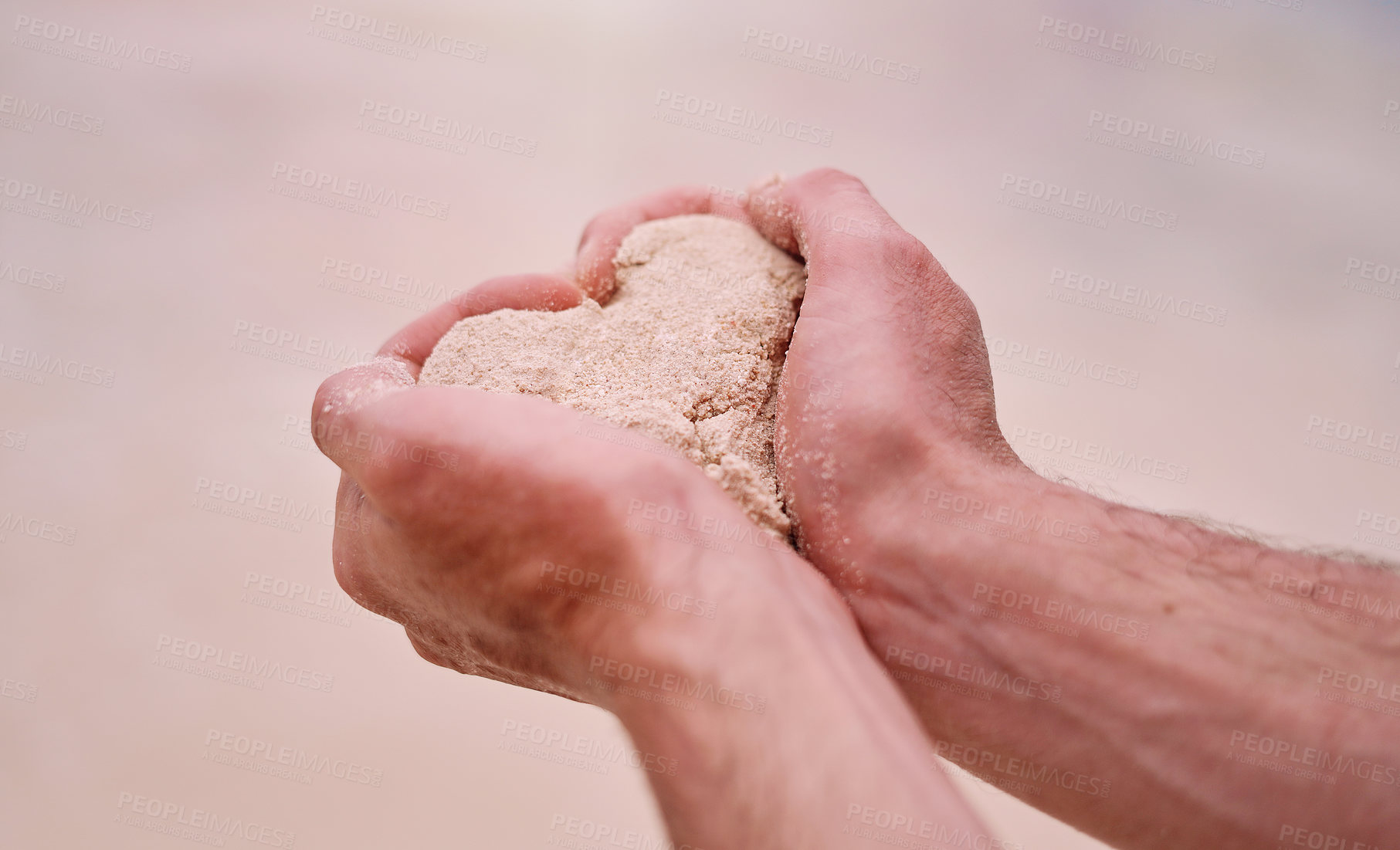 Buy stock photo Cropped shot of an unrecognizable man making a heart shape while holding sand on a beach