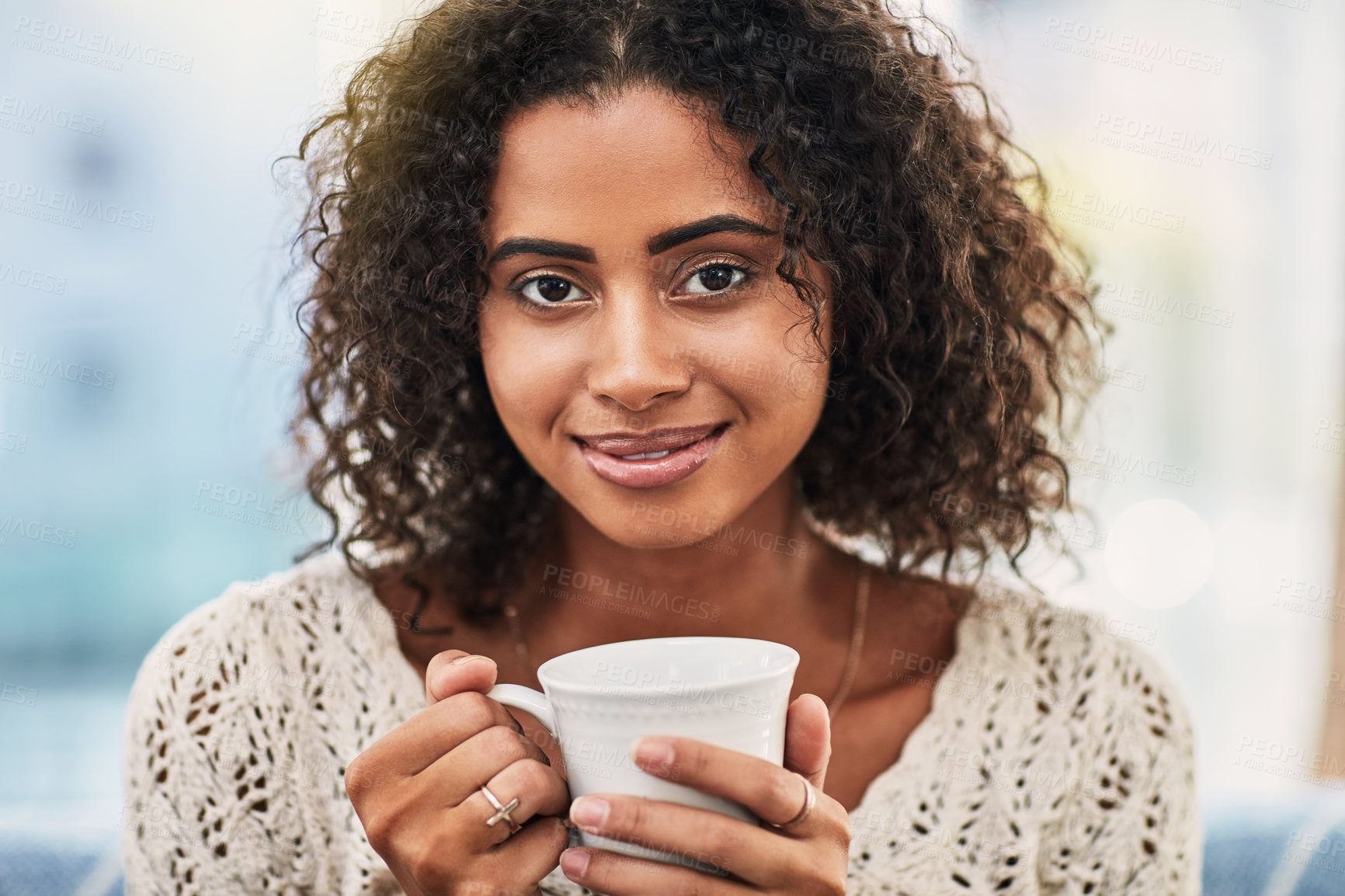 Buy stock photo Shot of an attractive young woman enjoying a cup of coffee at home