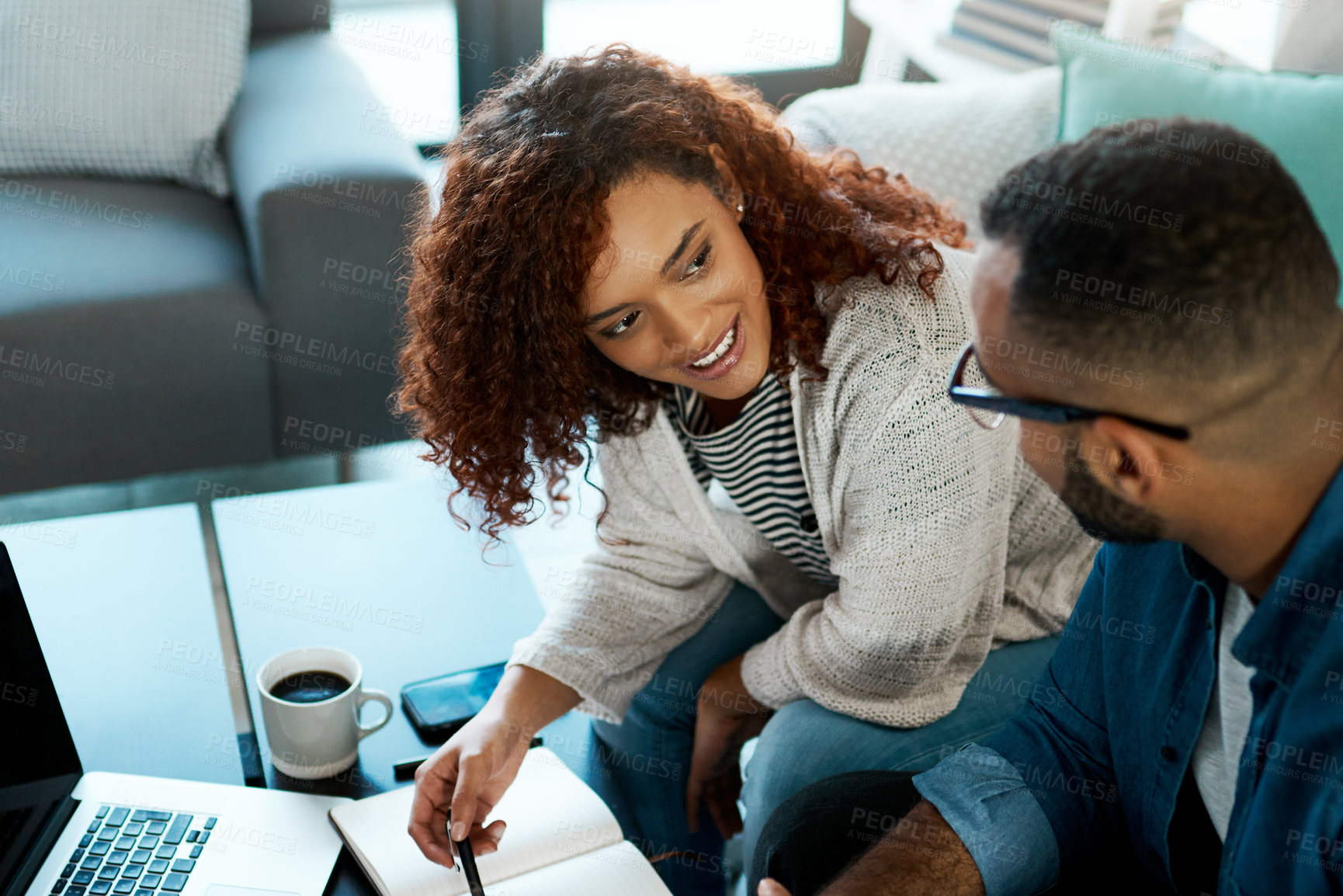 Buy stock photo Shot of a young couple planning their budget together at home