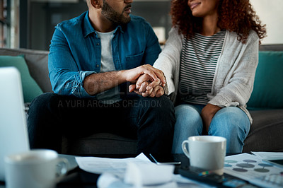 Buy stock photo Closeup shot of an unrecognisable couple holding hands while planning their budget together at home
