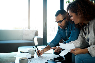 Buy stock photo Shot of a young couple planning their budget together at home