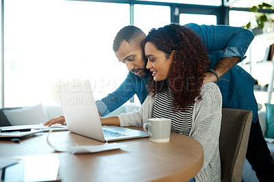 Buy stock photo Shot of a young couple planning their budget together on a laptop at home